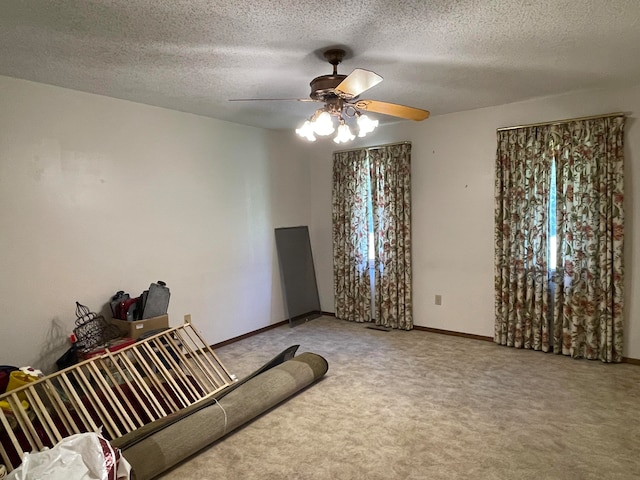 carpeted living room with ceiling fan and a textured ceiling