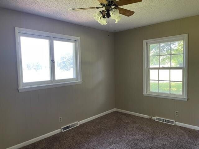 empty room featuring ceiling fan, a textured ceiling, and carpet