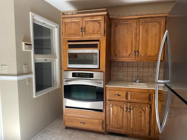 kitchen featuring appliances with stainless steel finishes, sink, and decorative backsplash