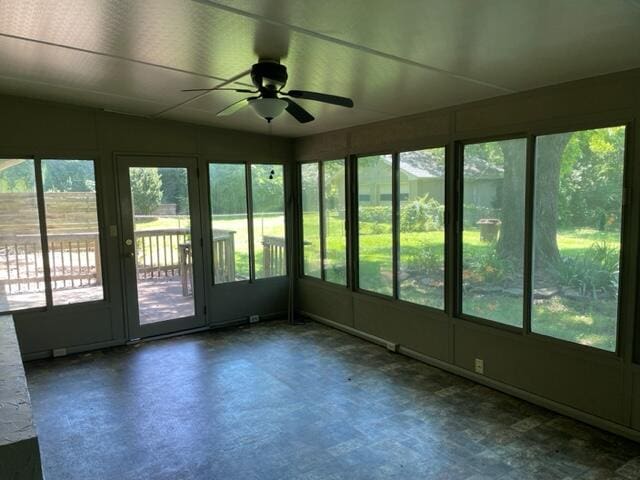 unfurnished sunroom with a wealth of natural light and ceiling fan