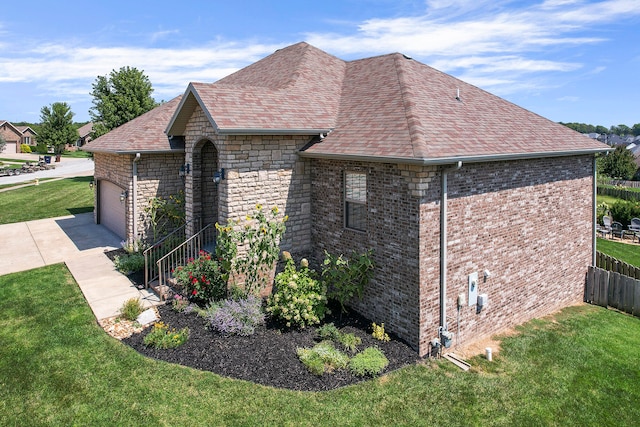 view of home's exterior with a garage and a lawn