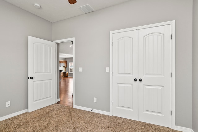 unfurnished bedroom with carpet floors, a closet, and ceiling fan