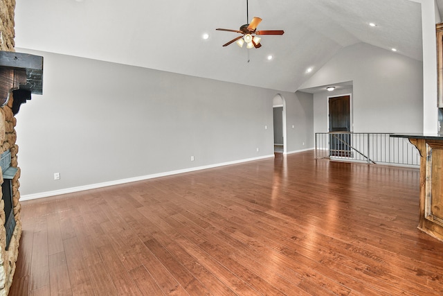 unfurnished living room with a stone fireplace, high vaulted ceiling, hardwood / wood-style flooring, and ceiling fan