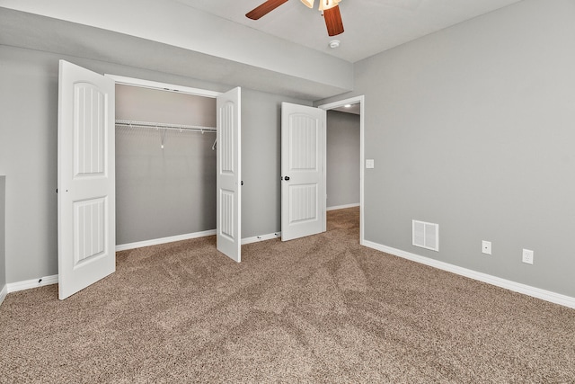 unfurnished bedroom with ceiling fan, a closet, and dark colored carpet