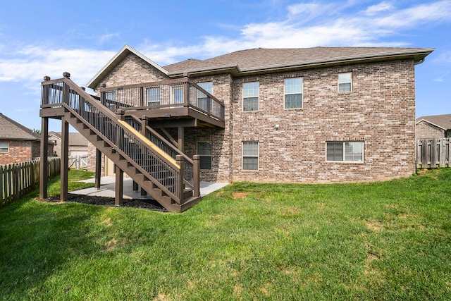 back of property featuring a wooden deck, a yard, and a patio area