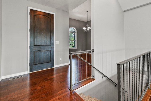 foyer with hardwood / wood-style flooring and an inviting chandelier