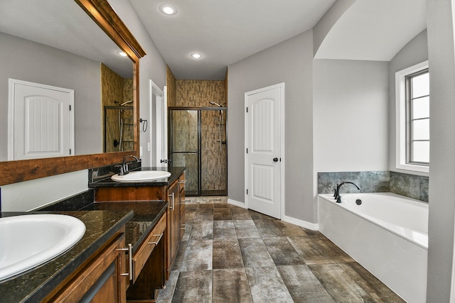 bathroom with vanity and shower with separate bathtub