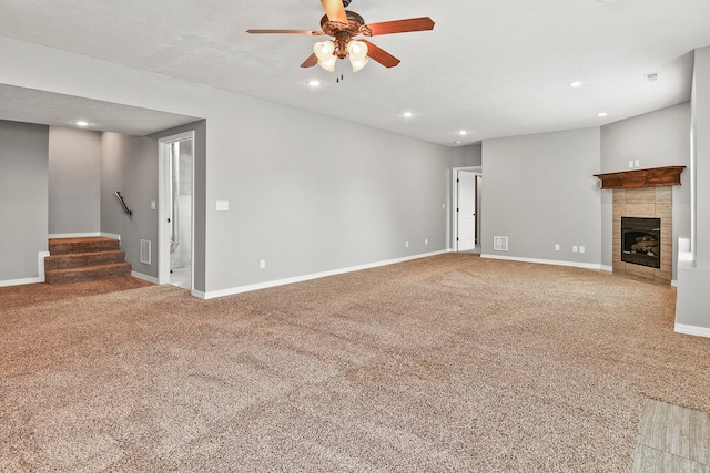 unfurnished living room featuring ceiling fan, a fireplace, and carpet flooring