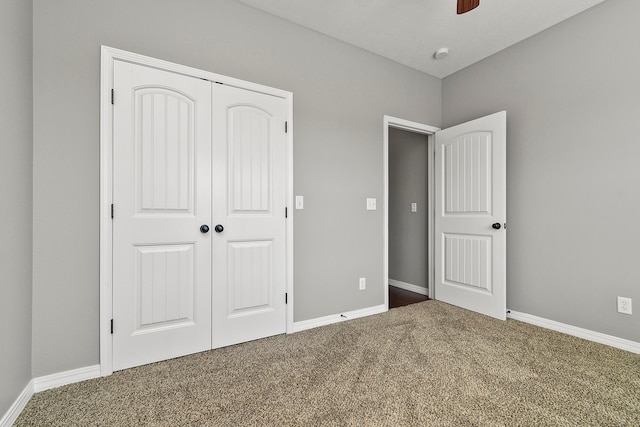 unfurnished bedroom featuring ceiling fan, a closet, and carpet flooring