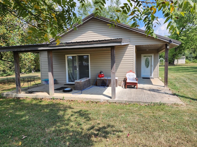 rear view of property featuring a shed, a patio, and a lawn