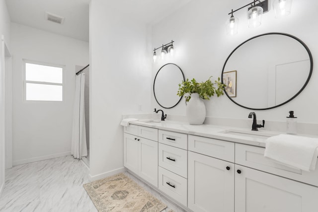 bathroom featuring visible vents, a sink, baseboards, and double vanity