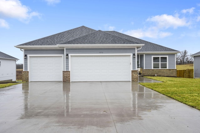 ranch-style house featuring an attached garage, brick siding, driveway, roof with shingles, and a front lawn