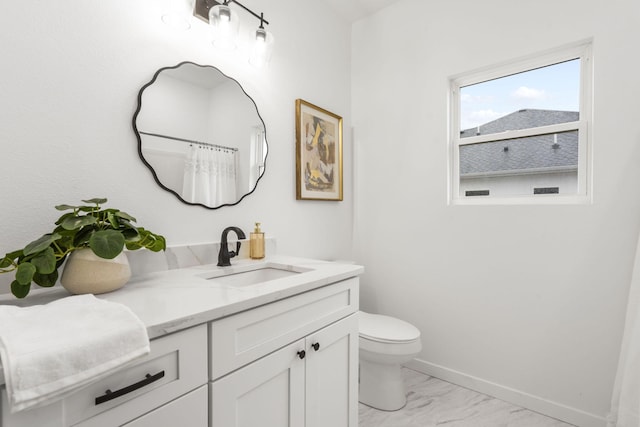 bathroom with toilet, marble finish floor, baseboards, and vanity