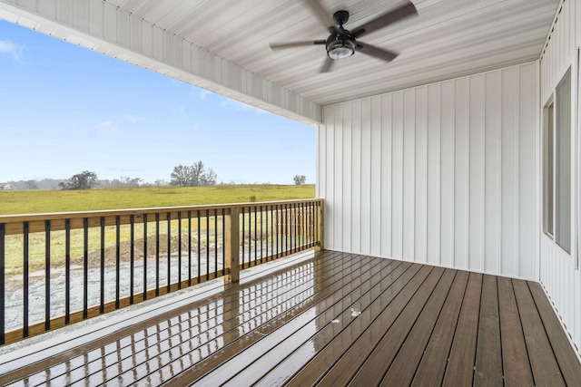 wooden deck featuring a yard, a rural view, and a ceiling fan