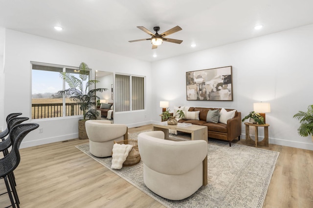 living room with recessed lighting, baseboards, and light wood finished floors