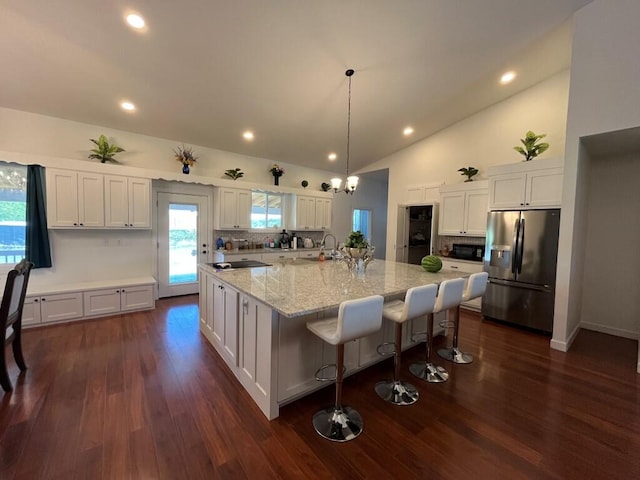 kitchen featuring stainless steel fridge, sink, a large island, white cabinetry, and dark hardwood / wood-style flooring