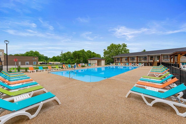pool featuring fence and a patio area