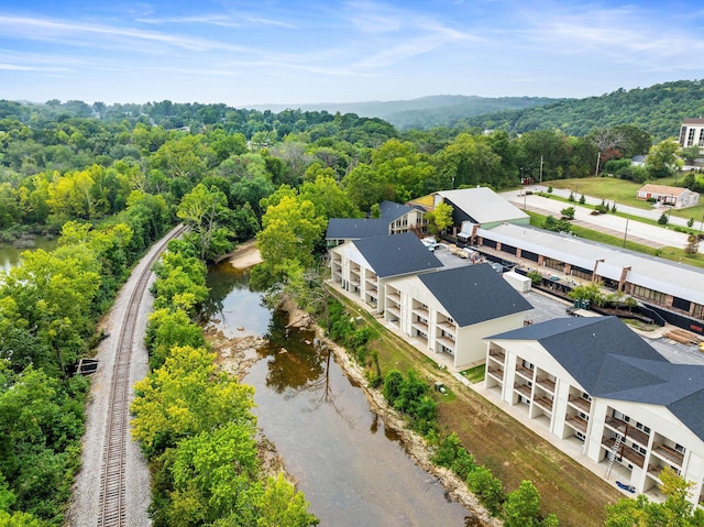 drone / aerial view with a forest view and a water view