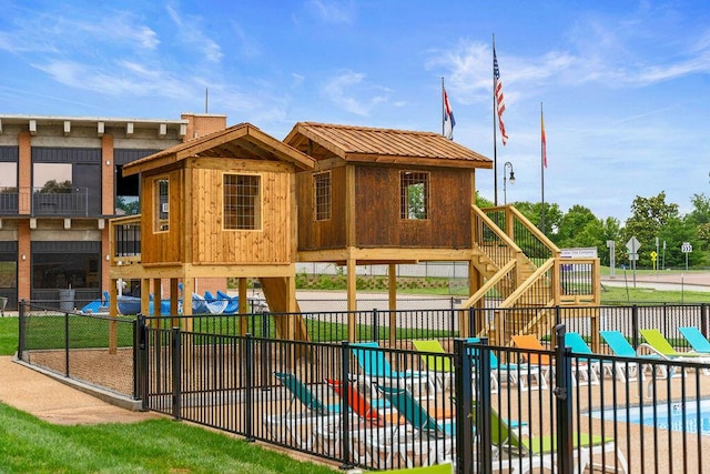 view of jungle gym featuring a community pool and fence