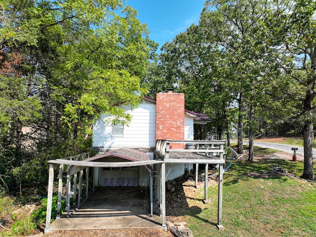 exterior space with a yard, a deck, and a carport