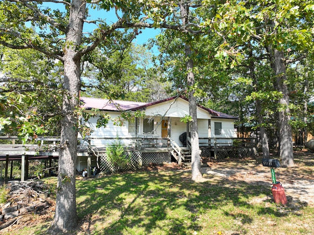 view of front of property with a front yard and a wooden deck