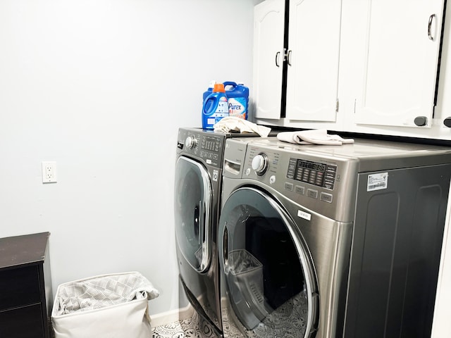 washroom featuring washing machine and clothes dryer and cabinets