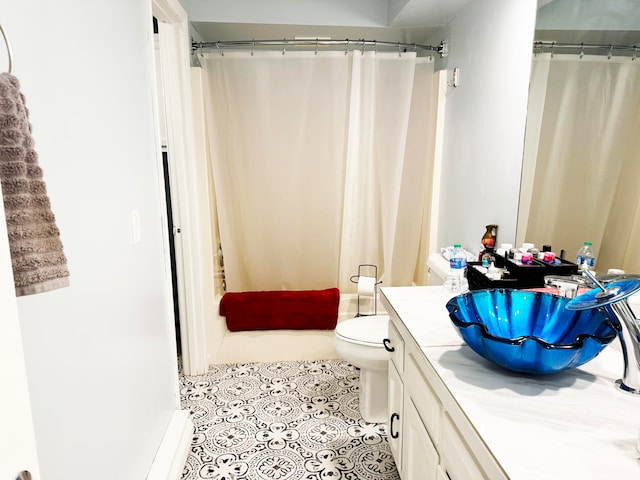 bathroom featuring walk in shower, tile patterned floors, vanity, and toilet