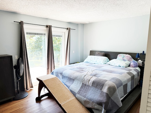 bedroom with hardwood / wood-style flooring and a textured ceiling