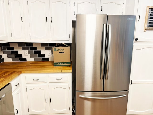 kitchen with backsplash, stainless steel appliances, and white cabinets