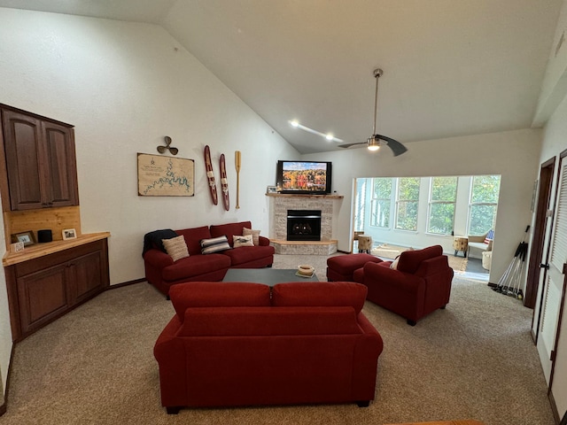 carpeted living room featuring ceiling fan, a fireplace, and high vaulted ceiling