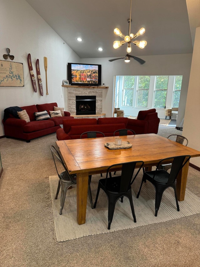 dining space featuring ceiling fan with notable chandelier, carpet floors, and vaulted ceiling