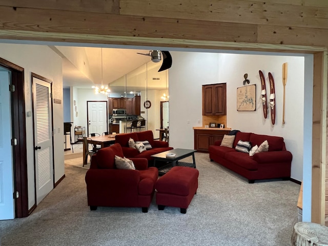 living room featuring light carpet, ceiling fan with notable chandelier, and vaulted ceiling