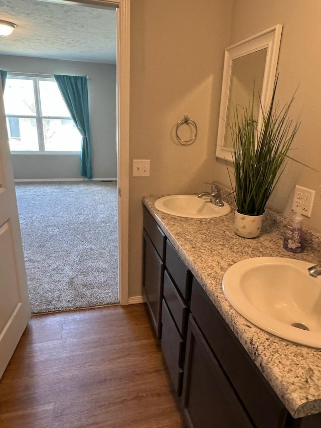 bathroom with vanity, hardwood / wood-style floors, and a textured ceiling