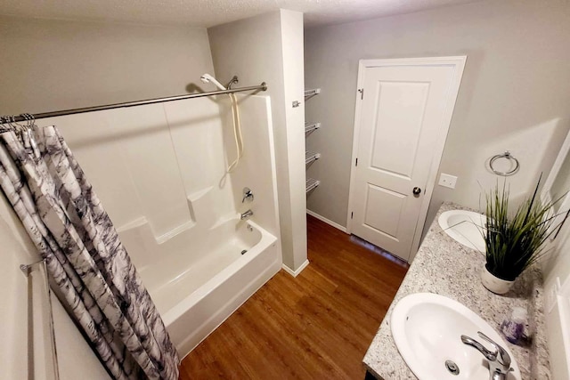 bathroom featuring vanity, a textured ceiling, shower / bath combo, and wood-type flooring