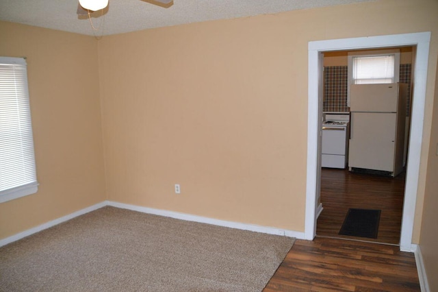 spare room featuring ceiling fan, dark hardwood / wood-style floors, and a textured ceiling