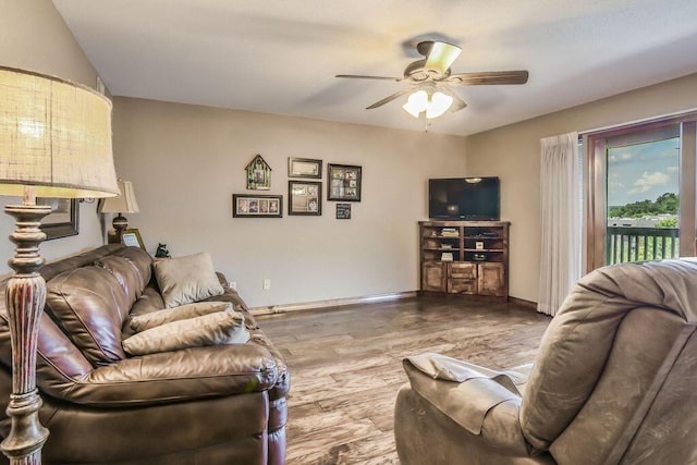 living area with baseboards, a ceiling fan, and wood finished floors