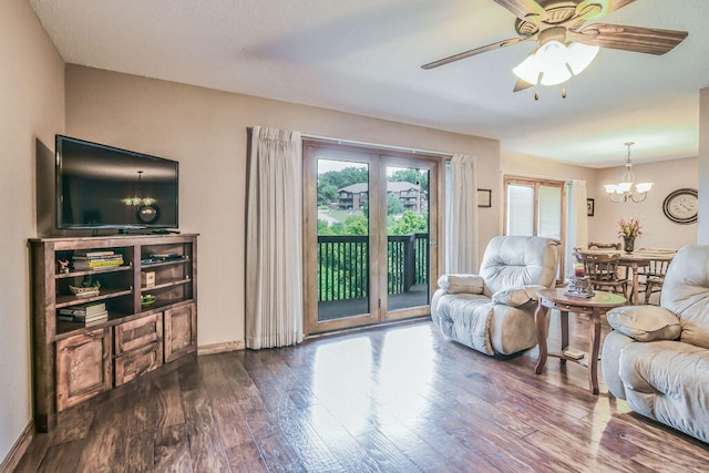 living room with ceiling fan with notable chandelier and hardwood / wood-style floors