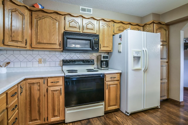 kitchen featuring a textured ceiling, dark wood-type flooring, white appliances, and tasteful backsplash