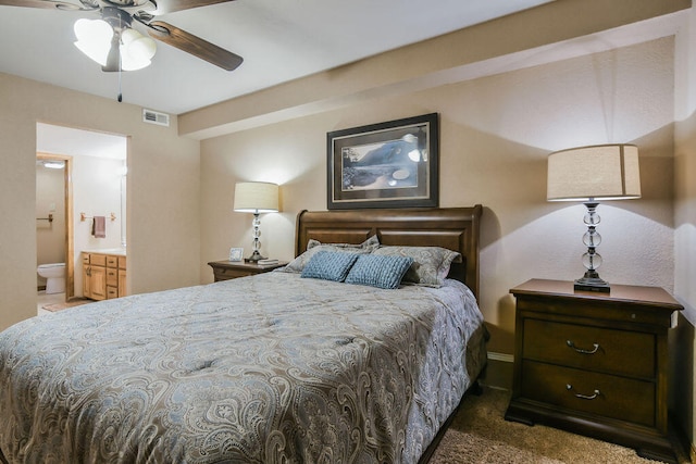 bedroom featuring ceiling fan, connected bathroom, and dark colored carpet