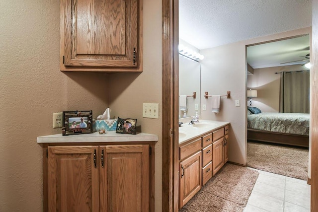 ensuite bathroom featuring tile patterned floors, double vanity, ensuite bath, a textured ceiling, and ceiling fan