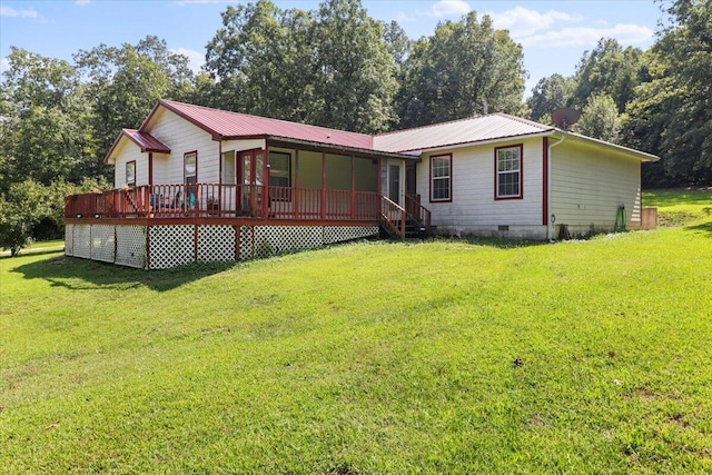 rear view of property with a wooden deck and a lawn