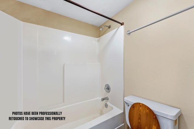 bathroom featuring bathtub / shower combination and toilet