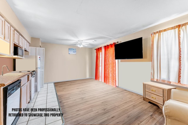 kitchen with light wood-type flooring, ceiling fan, light brown cabinets, sink, and appliances with stainless steel finishes