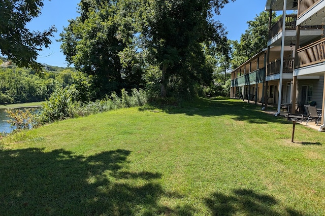 view of yard with a water view and a patio