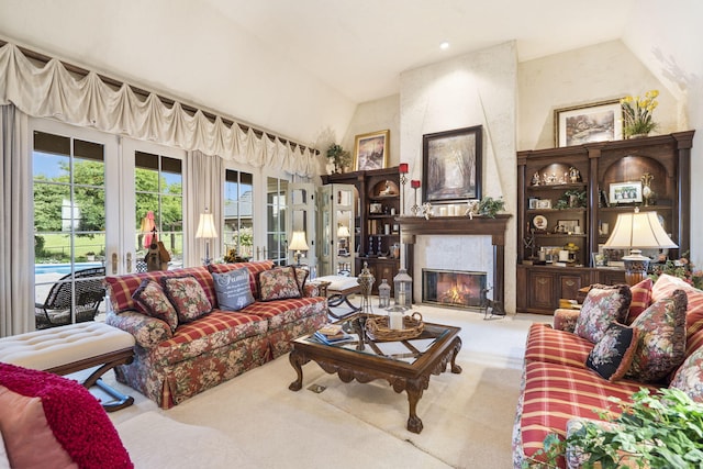 living room with a large fireplace, vaulted ceiling, and light colored carpet