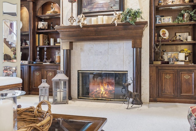 carpeted living room featuring a tiled fireplace