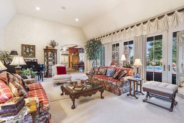 living room featuring light carpet, lofted ceiling, and french doors