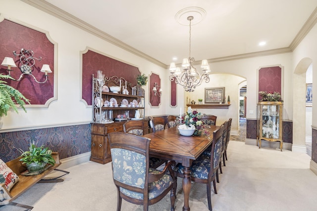 carpeted dining space with ornamental molding and a chandelier