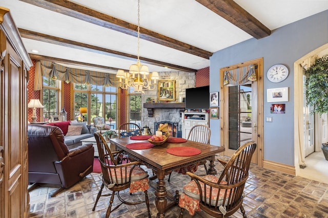 dining room featuring a fireplace, beam ceiling, and a chandelier