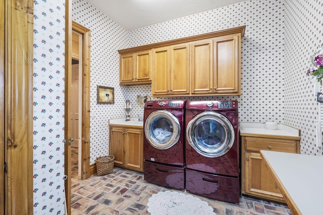 washroom featuring washer and clothes dryer and cabinets